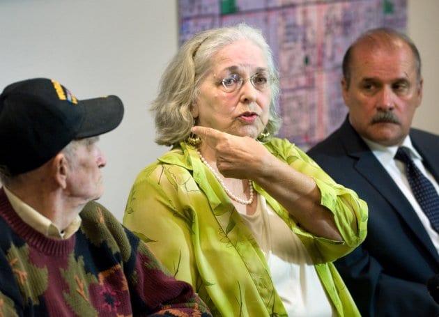 Jan Cooper, 72, talks to the media as her husband Bob, 85, left, and OC Sheriff's spokesman Jim Amormino listen during a news conference at the Sheriff's Department station in Stanton on Tuesday, June 11, 2013. Jan Cooper showed where the Sheriff's estimated the bullet traveled, based on the size of the suspect and the damage to her sliding glass door, when she scared off an intruder at her home in unincorporated Anaheim on Sunday, June 9, by firing a shot from her .357 Magnum during the attempted break-in. The bullet went through the frame of her sliding glass door and just missed the intruder. The suspect, Brandon Alexander Perez, is in custody. (AP Photo/The Orange County Register, Paul Bersebach) MANDATORY CREDIT THE ORANGE COUNTY REGISTER, LA TIMES, MAGS OUT