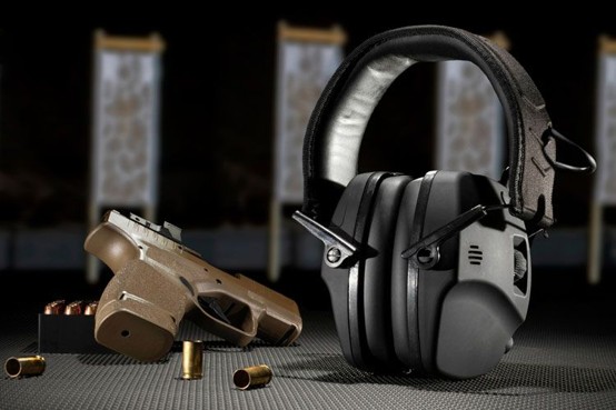 Shooter wearing ear protection and safety glasses at indoor shooting range